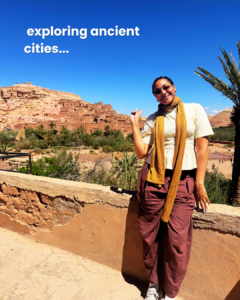 A photo of a woman in front of Ksar of Ait-Ben-Haddou